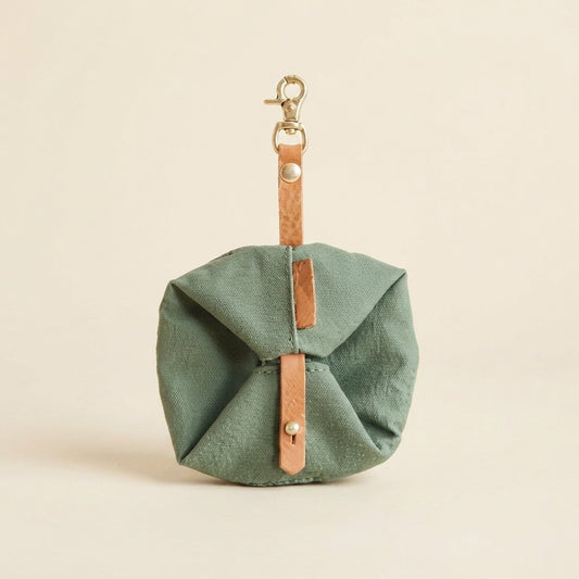 WilderPaw RoamBowl foldable travel dog bowl in sage green, folded and clipped shut